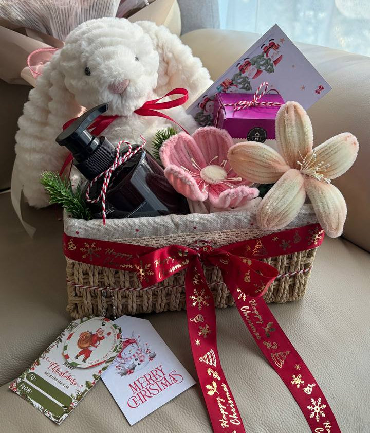 Gift basket with plush toy, flowers, and cards on a couch